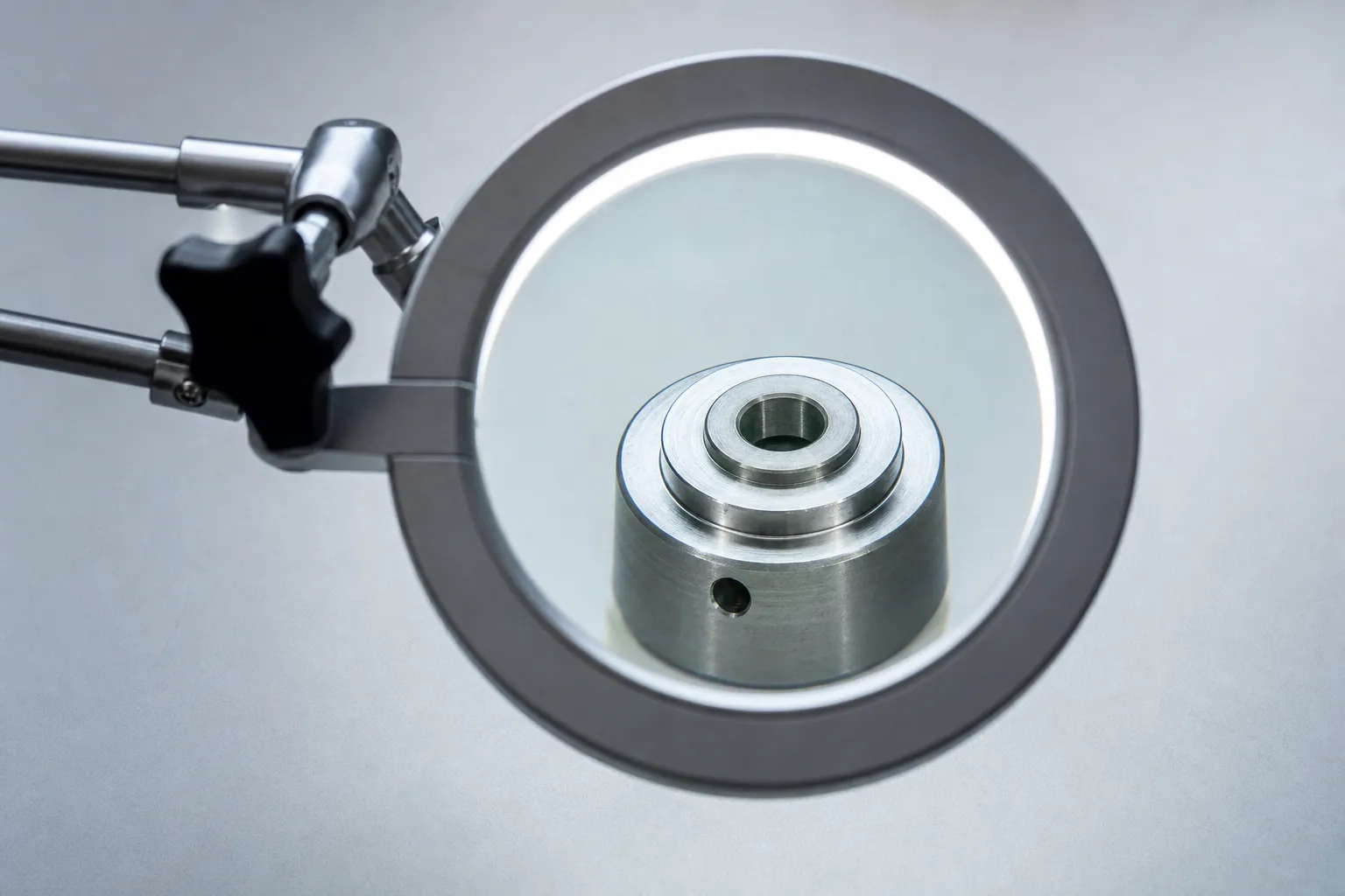 Contrôle visuel d'une pièce à la loupe d'atelier sous éclairage dirigé